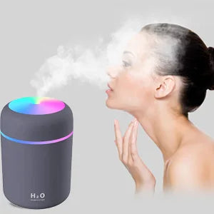 Woman enjoying cool mist from H2O mini humidifier