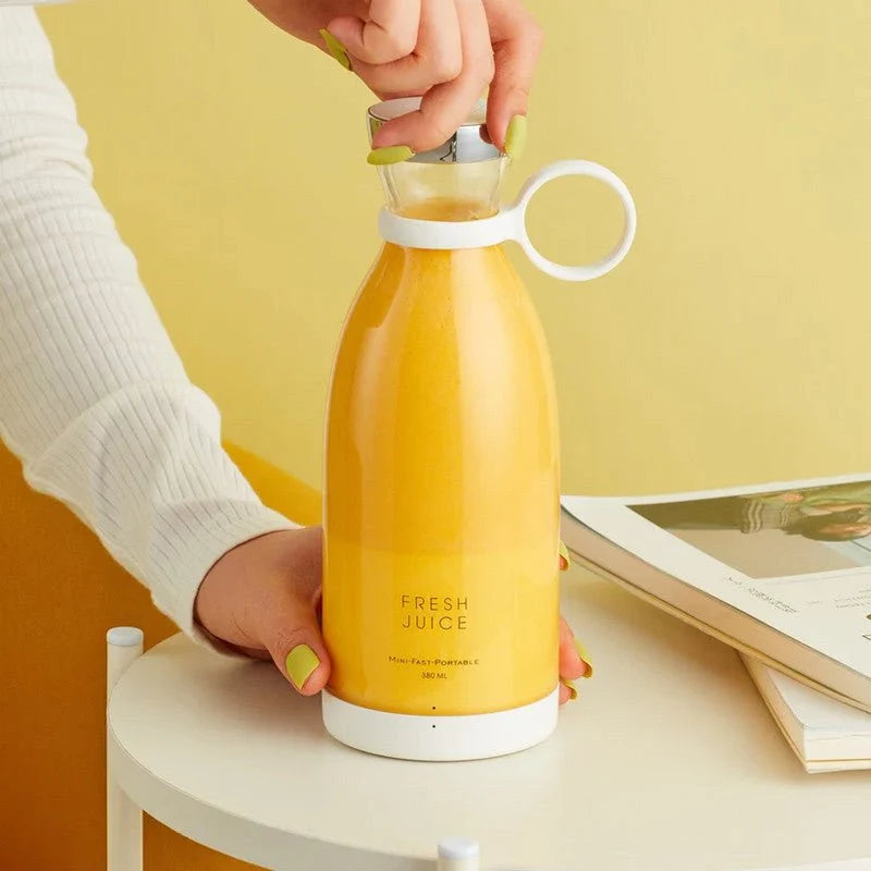 Woman adding strawberries to portable juicer bottle